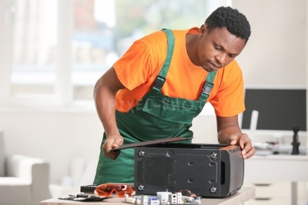 African-American technician repairing computer in service center