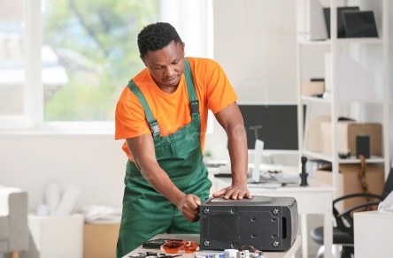 African-American technician repairing computer in service center