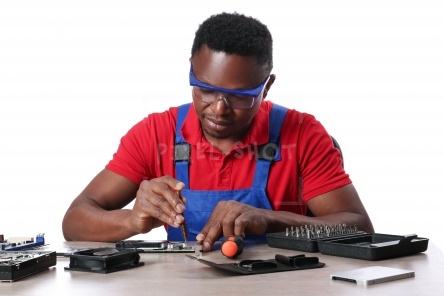 African-American technician repairing computer on white background