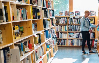 Person perusing books at Powells bookstore.