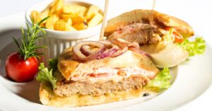 Tasty Pork Tenderloin Sandwich with Onions, Lettuce and Fries