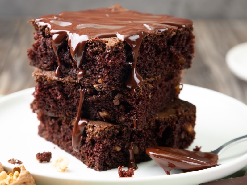 Three Slices of Brownies on a White Saucer with Dripping Chocolate