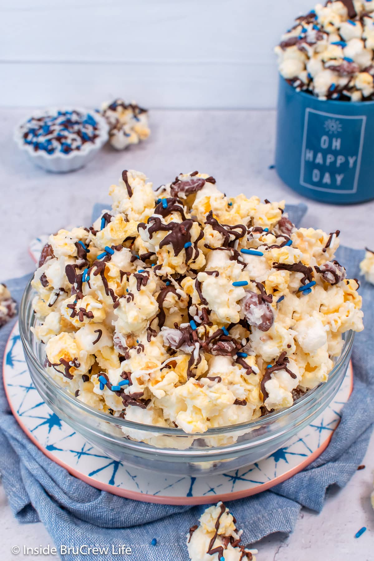 A clear glass bowl filled with a coconut almond popcorn mixture.