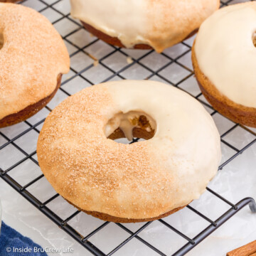 Glazed donuts cooling on a wire rack.