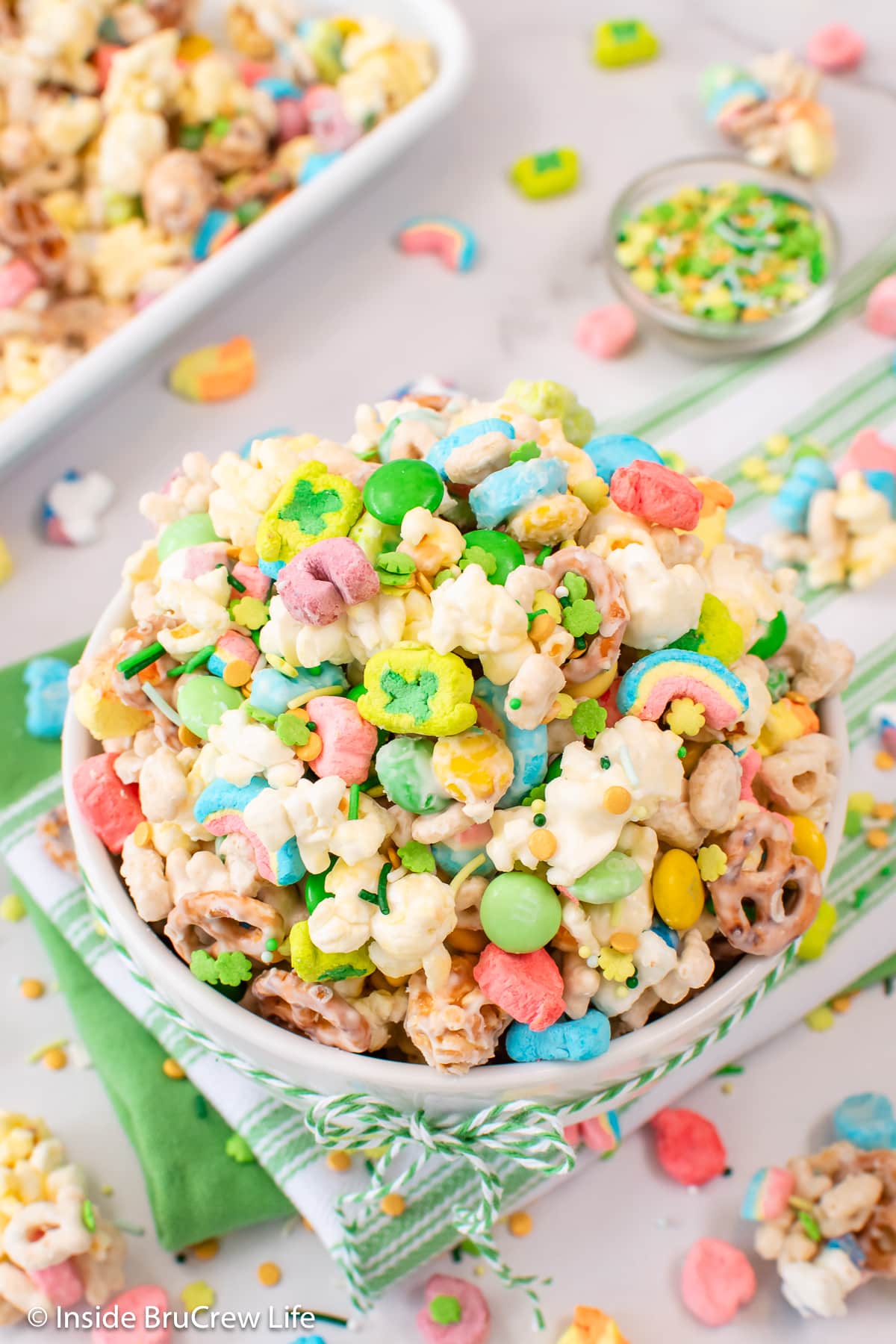 A white bowl filled with popcorn and Lucky charms cereal.