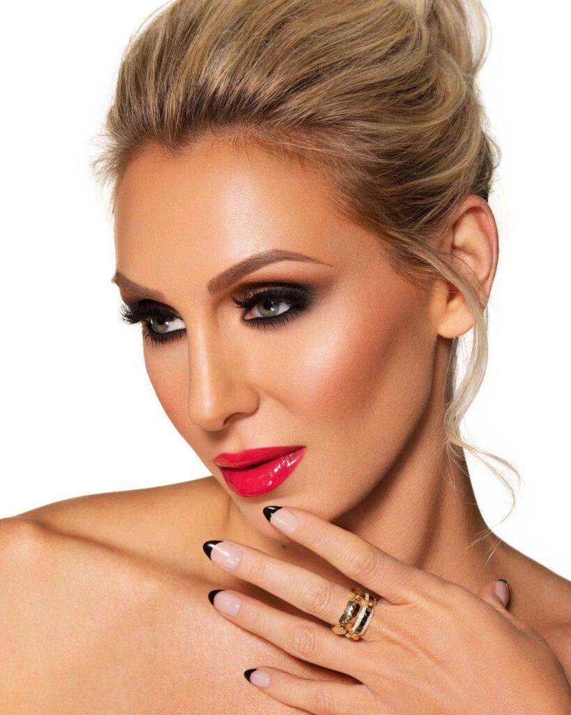 Charlotte Flair is looking hot in red lipstick and wearing ring in hand and posing for the picture