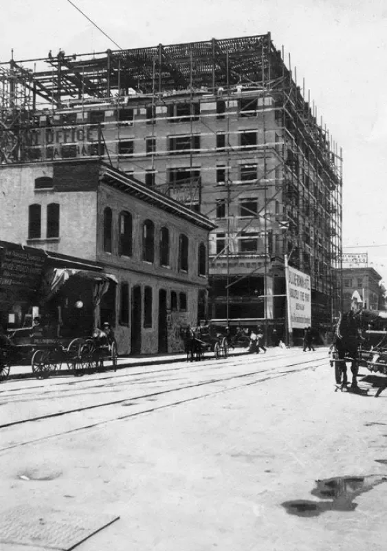 A black and white photo of a building under construction