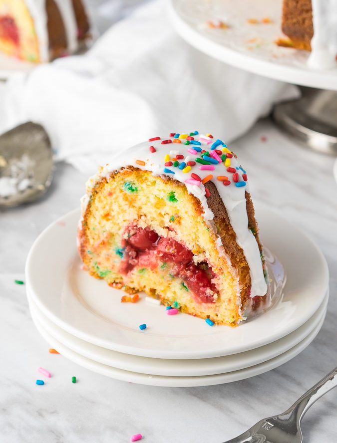 This Cherry Surprise Cake is a moist funfetti cake that's filled with cherry pie filling! So fun and so delicious, my whole family loved it!