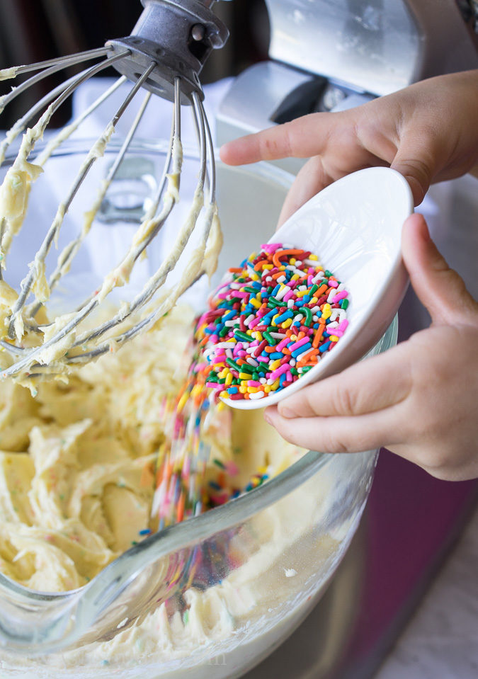 This Cherry Surprise Cake is a moist funfetti cake that's filled with cherry pie filling! So fun and so delicious, my whole family loved it!