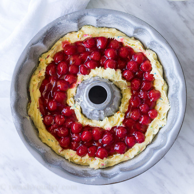 This Cherry Surprise Cake is a moist funfetti cake that's filled with cherry pie filling! So fun and so delicious, my whole family loved it!