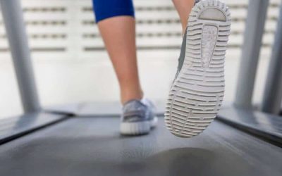 A woman running on a treadmill wearing trail shoes