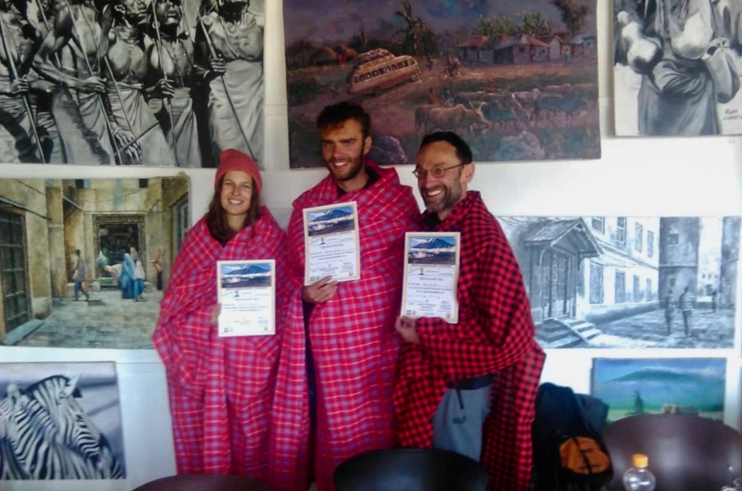 Three mountaineers after a successful ascent of Kilimanjaro