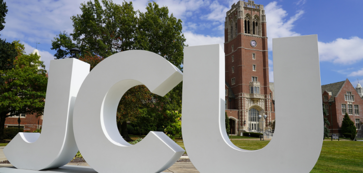 JCU outdoor letters on campus in front of clock tower