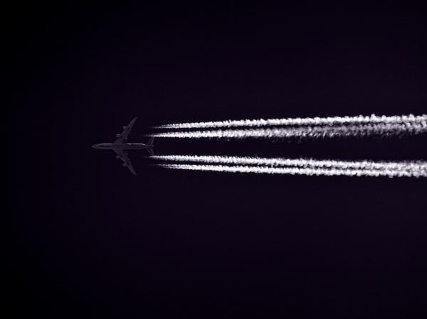 Photo of Airplane Across the Clouds during Night Time