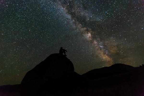 Silhouette of Person Sitting on Rock