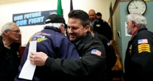 IAM District 751 president Jon Holden greets union members after announcing they voted to accept a new contract offer from Boeing, Monday, Nov. 4, 2024, at their union hall in Seattle. (AP Photo/Lindsey Wasson)