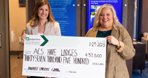 Amy Cook, senior director of operations at Paycom, and a representative from the American Cancer Society hold a $37,500 donation check for Hope Lodge communities. (Photo/Paycom)