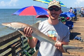 andrew juran holding shark on fishing pier