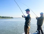 andrew juran on a boat reeling in a fish using a spinning fishing rod and reel