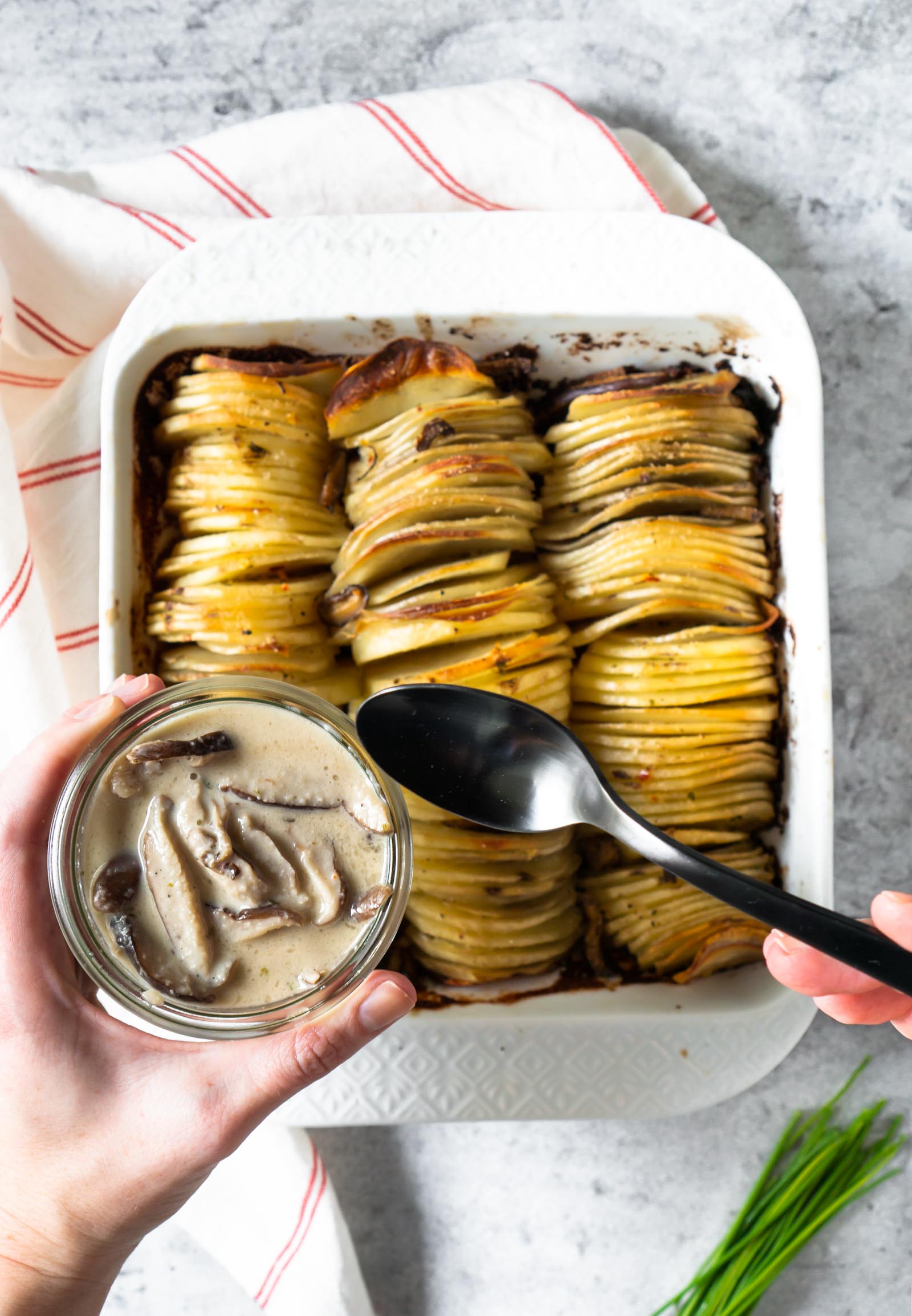 creamy mushroom sauce, hasselback potato gratin, and a black spoon