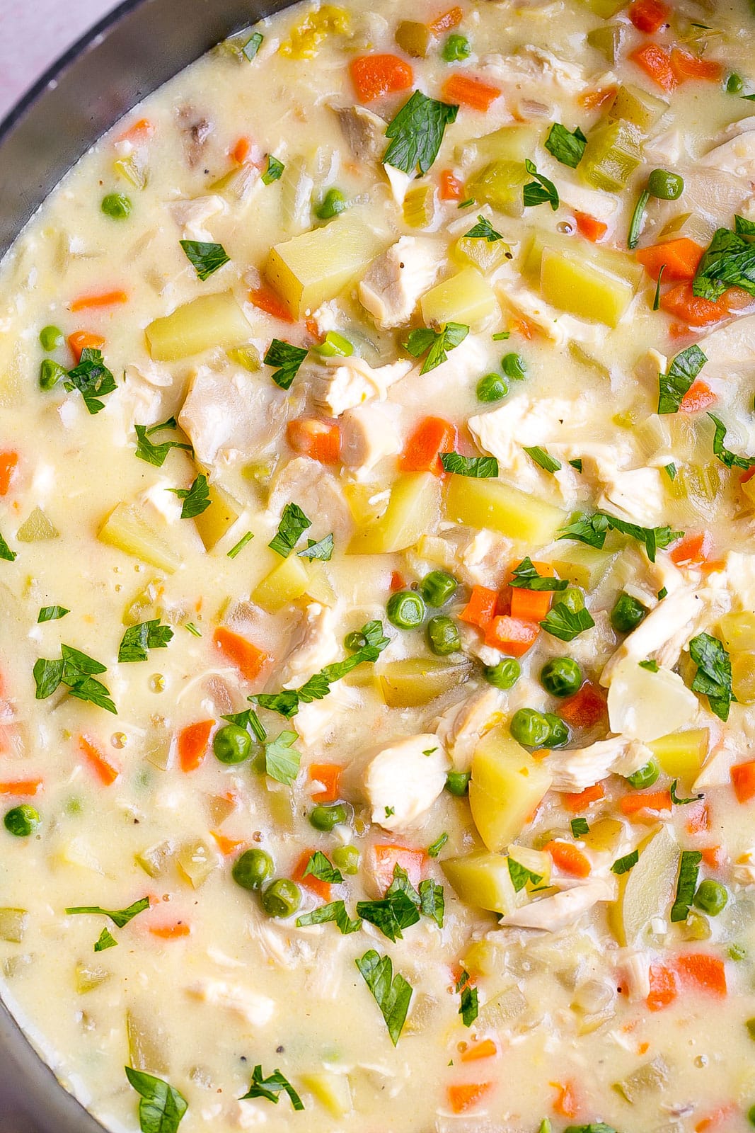 Chicken Pot pie soup in a large pot with parsley on top.