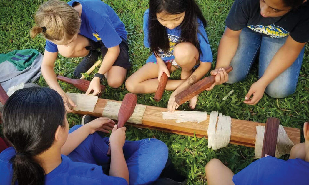 Mr. Aron Michelson's science class at Laupahoehoe Middle School participates in kuku kapa (beating the kapa). photo courtesy of Jennifer Rose