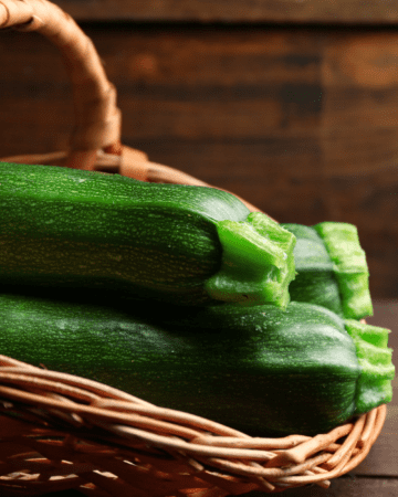 zucchini in wicker basket with wood in background