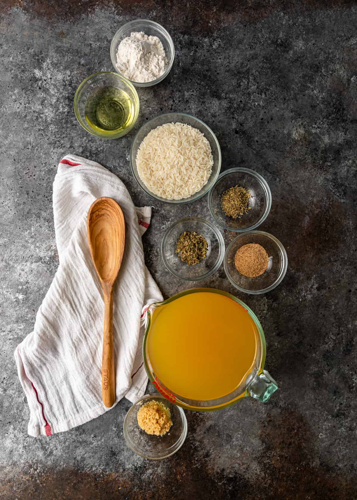 overhead: bowls of rice, seasoning, oil, and broth needed for jambalaya 