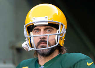 a man with a beard wearing a green and yellow football uniform