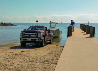 a truck parked on a dock next to a boat