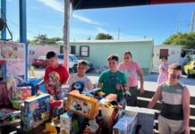 a group of people standing around a table filled with toys