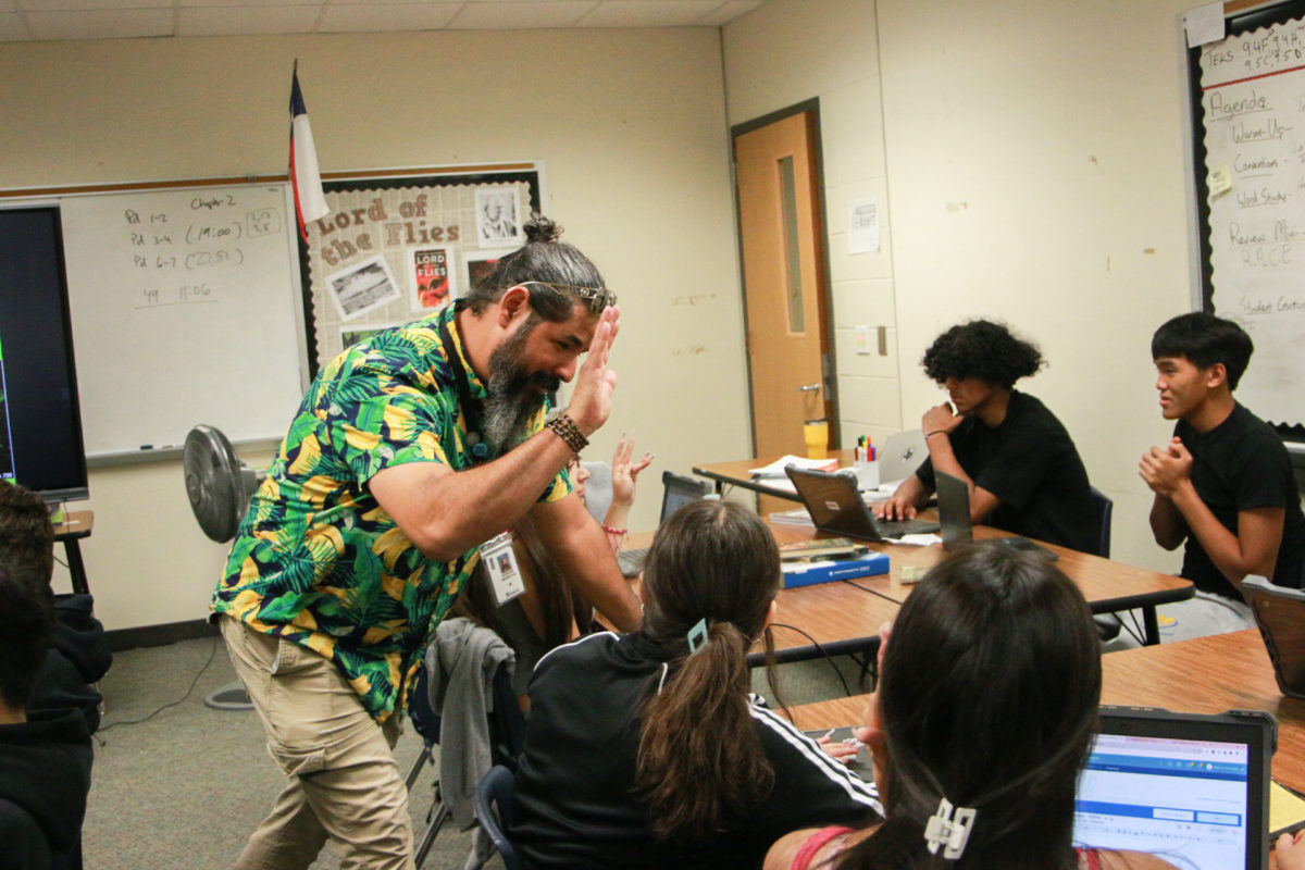 With a proud smile on his face, Adrian Sendejas holds his hand out to freshman Nathaly Jarquin to give her a high-five for her work.