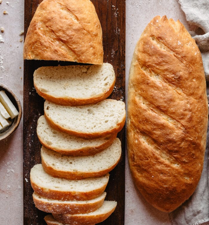 a sliced loaf of bread and a whole loaf of bread next to it.