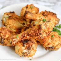 Overhead picture of air fryer chicken legs laying on a white plate