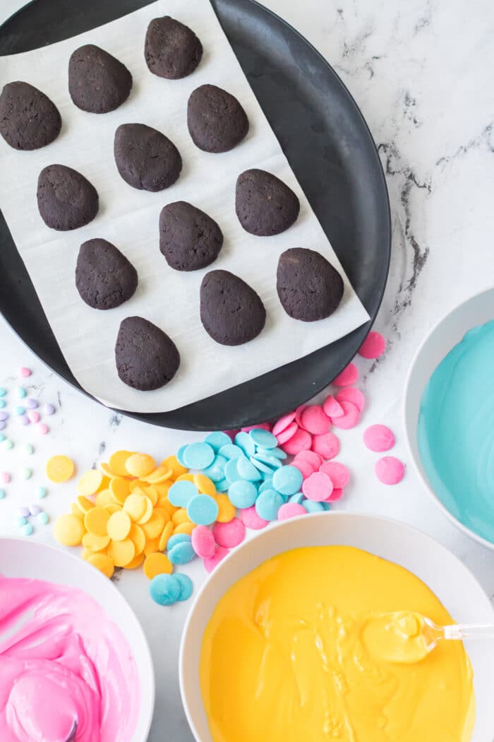 A parchment paper lined sheet with the Oreo balls on.