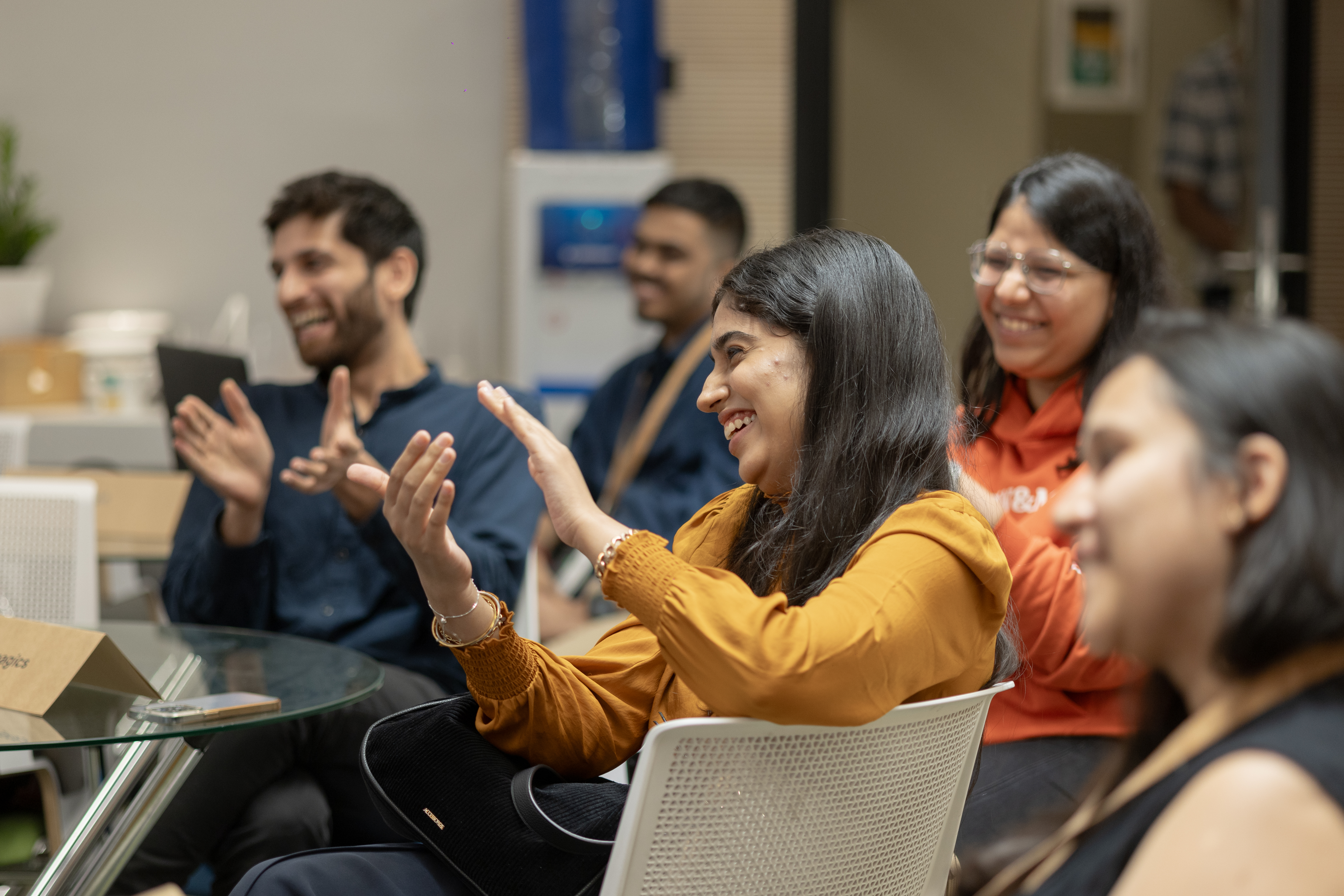 A group of people clapping while laughing