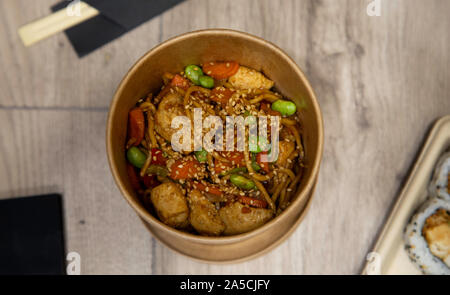 Sauteed yakisoba noodles with seriva chicken meat in an ecological bowl, Asian style food. Top view Stock Photo