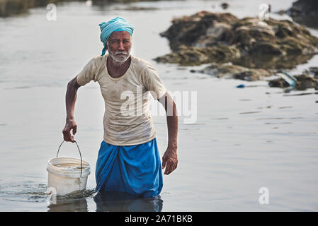 Men washing and drying colorful clothes, River Laundry service nearby Taj Mahal, Agra, India Stock Photo