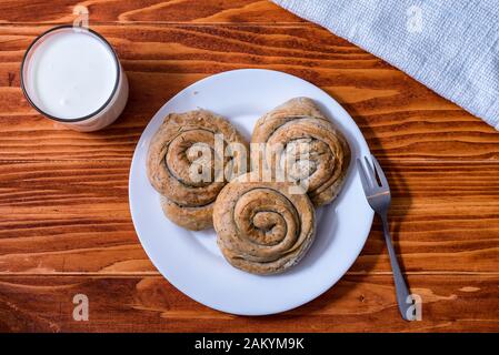 Domestic Home made Rolled pastry with spinach and cheese on a napkin with a glass of Yogurt Stock Photo