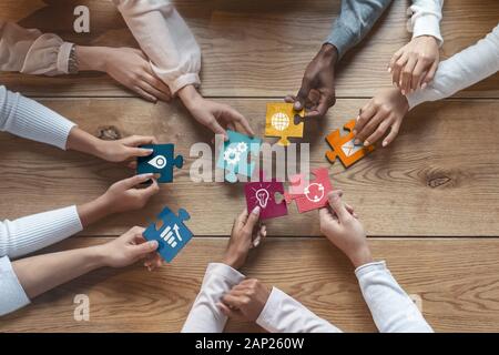 International team of coworkers putting colorful puzzles together Stock Photo