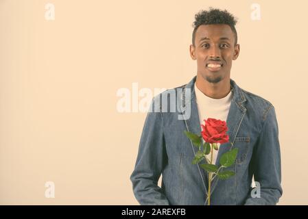 Young bearded African man wearing denim jacket against white background Stock Photo