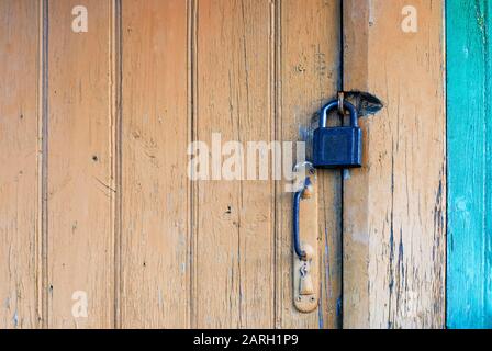 Old closed door with padlock and knob Stock Photo