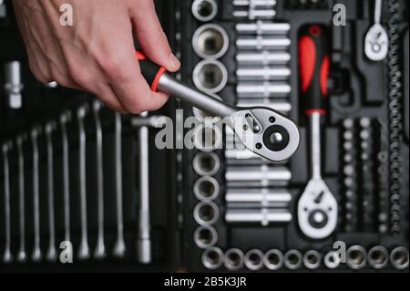 human hand with car repair tool on tool box kit background Stock Photo