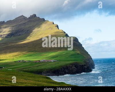 Faroe Islands, Viðoy, Viðareiði. Spectacular view on cliffs and green hills above the village. Blue sky with some while clouds. Stock Photo