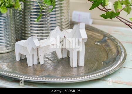 Small Dalecarlian or Dala horses on a metal dish Stock Photo