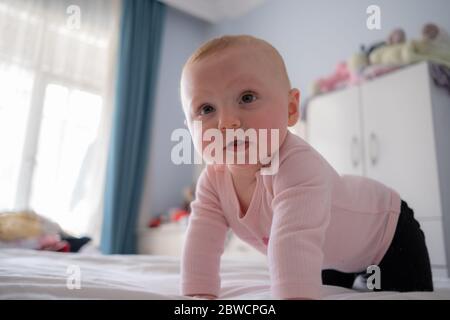 Cute baby girl standing on bed make funny faces, angry face, crying in the morning Stock Photo