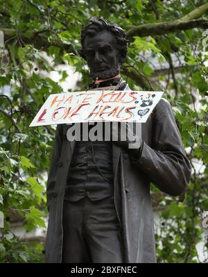 A sign reading Hate Kills, Love Heals hung around the statue of Abraham Lincoln in Parliament Square, in the aftermath of a Black Lives Matter protest rally in memory of George Floyd who was killed on May 25 while in police custody in the US city of Minneapolis. Stock Photo