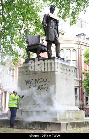 A worker cleans graffiti from the plinth of the statue of Abraham Lincoln at Parliament Square in London, following a Black Lives Matter protest at the weekend. A raft of protests across the UK were sparked by the death of George Floyd, who was killed on May 25 while in police custody in the US city of Minneapolis. Stock Photo