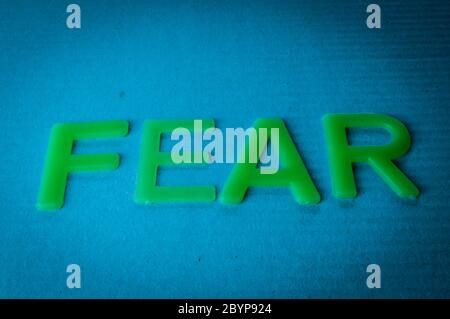 Fear. Word made by green letters on blue background. Stock Photo