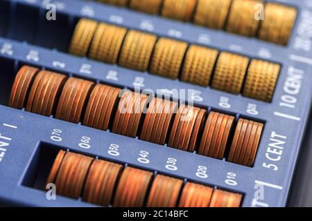 Open cash registrer containing many coins of euros in raw Stock Photo